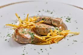 A puréed and simmering carrot soup in a pot with a spoon